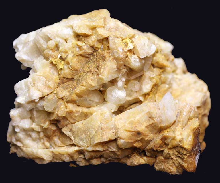 Image couleur d’une roche jaune avec multiples bords dentelés et morceaux ronds de roche blanche