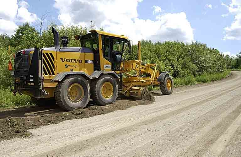 Niveleuse à la réfection d’un chemin de gravier