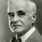 Black and white photograph of man with gray hair in a suit and a bowtie